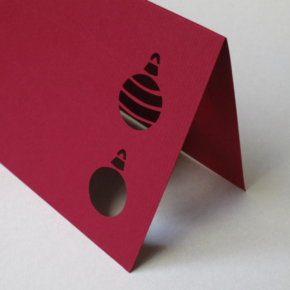 dunkelrote Weihnachtskarte: gestanzte Christbaumkugeln